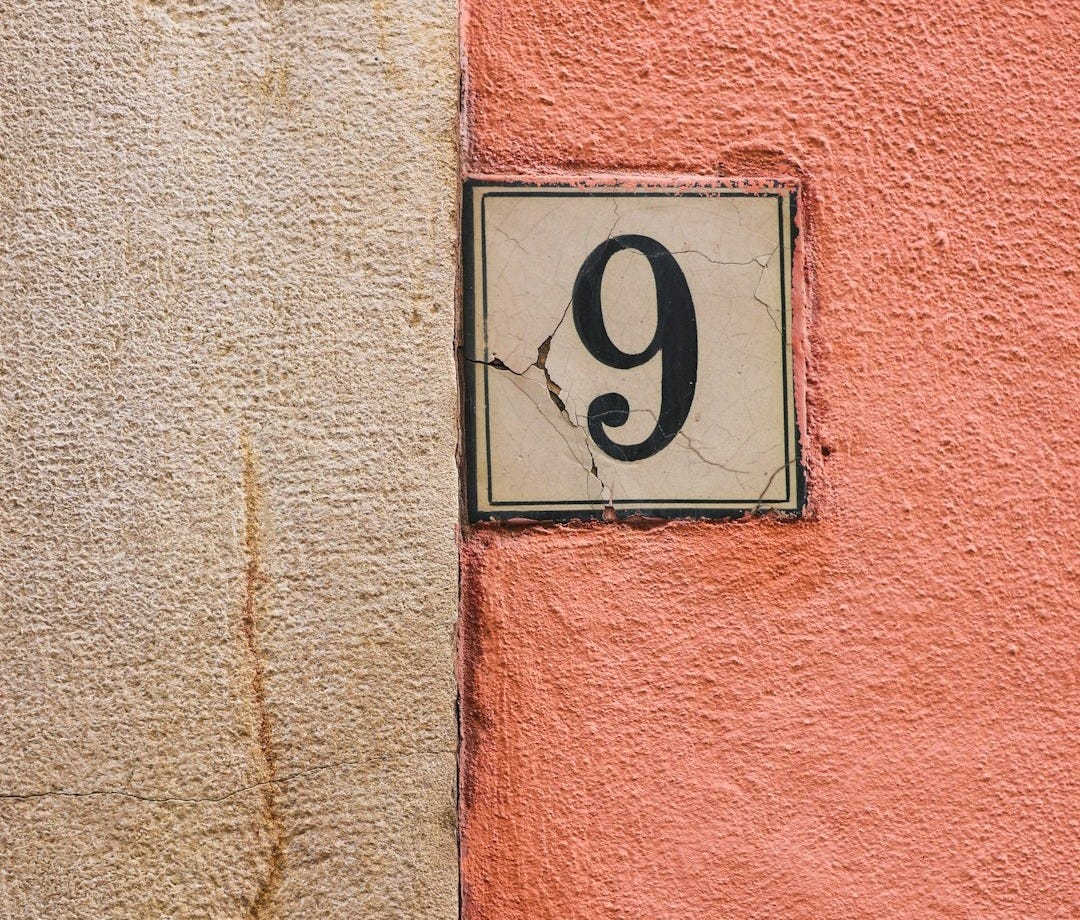 a number nine sign mounted to the side of a building