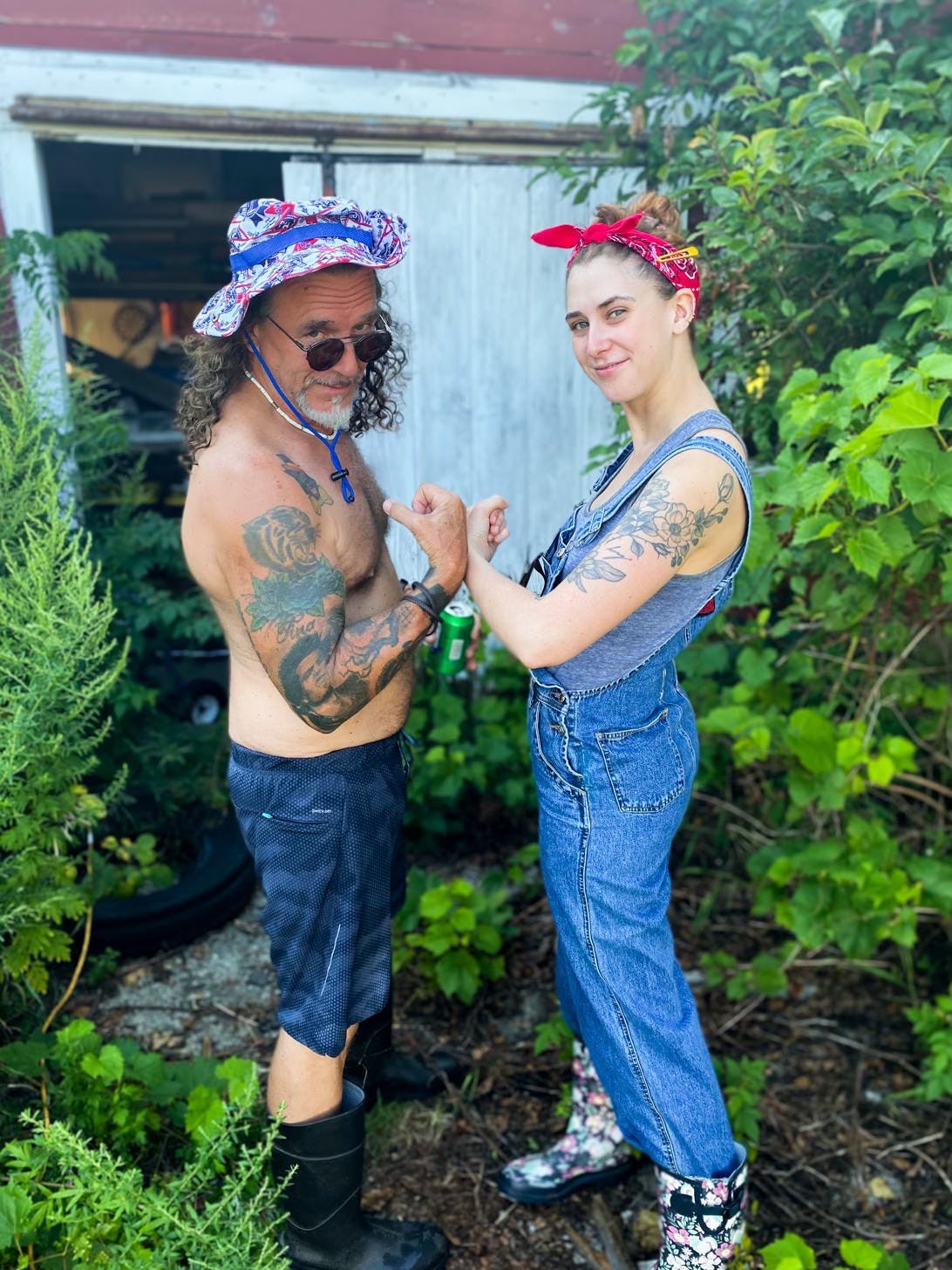 Man and younger woman posing with flexed biceps in front of barn door