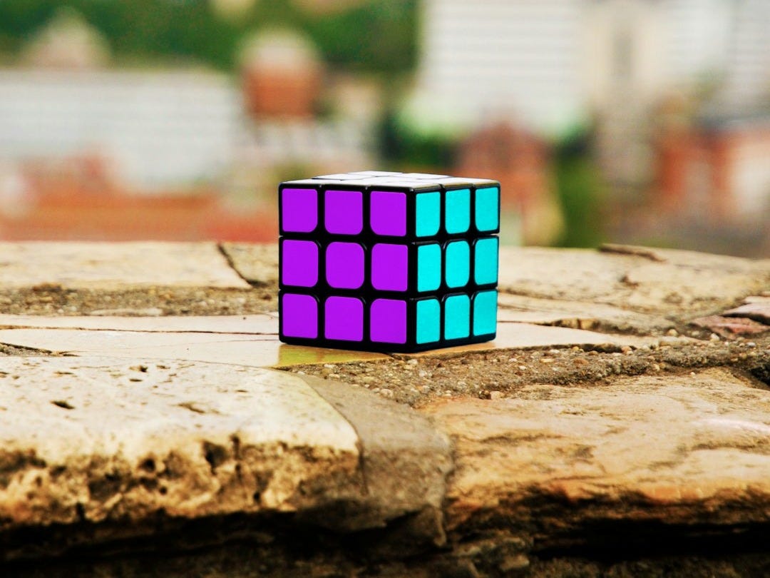a rubik cube sitting on top of a piece of wood