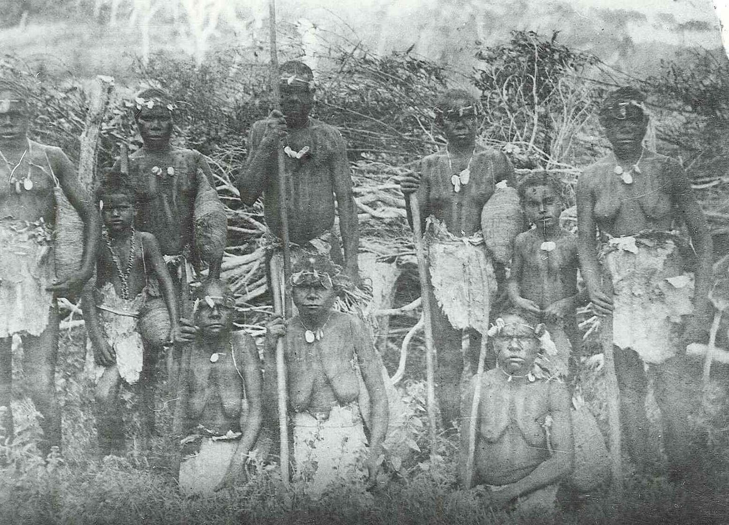 Photo taken at the Lucas Homestead on Great Keppel Island circa 1897. Konomie is second from left, with her mother Judy sitting in the centre. Judy’s brother, James/Jimmy, stands behind her holding a harpoon and rope. On the far right is Konomie’s younger brother, Fred. Most people are holding dilly bags, and the women yam sticks. They are wearing nautilus shell and red toad stool headdresses and necklets. This is a staged photo, as Dr Roth dressed them in bark skirts, which was not their traditional dress. Image: unknown © John Oxley Library, State Library of Queensland Photo taken at the Lucas Homestead on Great Keppel Island circa 1897. Konomie is second from left, with her mother Judy sitting in the centre. Judy’s brother, James/Jimmy, stands behind her holding a harpoon and rope. On the far right is Konomie’s younger brother, Fred. Most people are holding dilly bags, and the women yam sticks. They are wearing nautilus shell and red toad stool headdresses and necklets. This is a staged photo, as Dr Roth dressed them in bark skirts, which was not their traditional dress. Image: unknown © John Oxley Library, State Library of Queensland