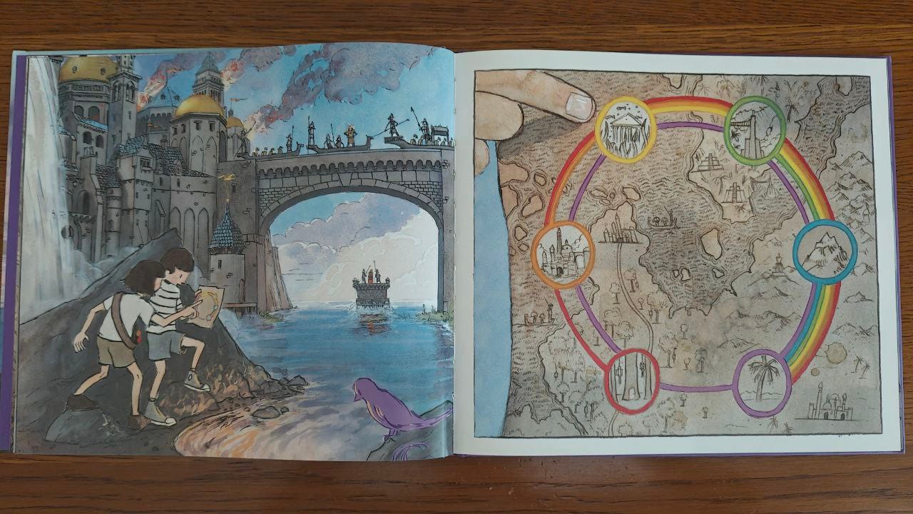 Doppia pagina del libro "Viaggio" di Aaron Becker appoggiata su un tavolo di legno marrone. A sinistra l'illustrazione di bambino e bambina che scrutano una mappa con un castello in fiamme sullo sfondo; a destra primo piano della mappa con sei punti colorati di giallo, rosso, violetto, blu, giallo, verde.