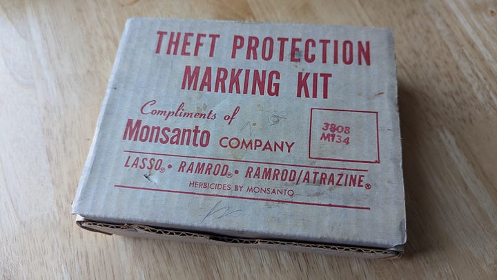 a beat-up cardboard box with writing on the outside and some pencil marks, with another box and a rubber stamp inside
