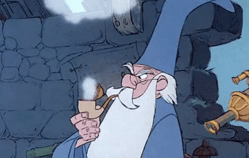Gif da "La spada nella roccia" con mago Merlino a mezzobusto di profilo, che guarda verso sinistra con cipiglio arrabbiato e fuma una pipa, da cui salgono nuvolette di fumo. Sullo sfondo l'interno di una casa in muratura color cinerino e sulla destra il dettaglio dorato di un telescopio che punta verso il cielo.