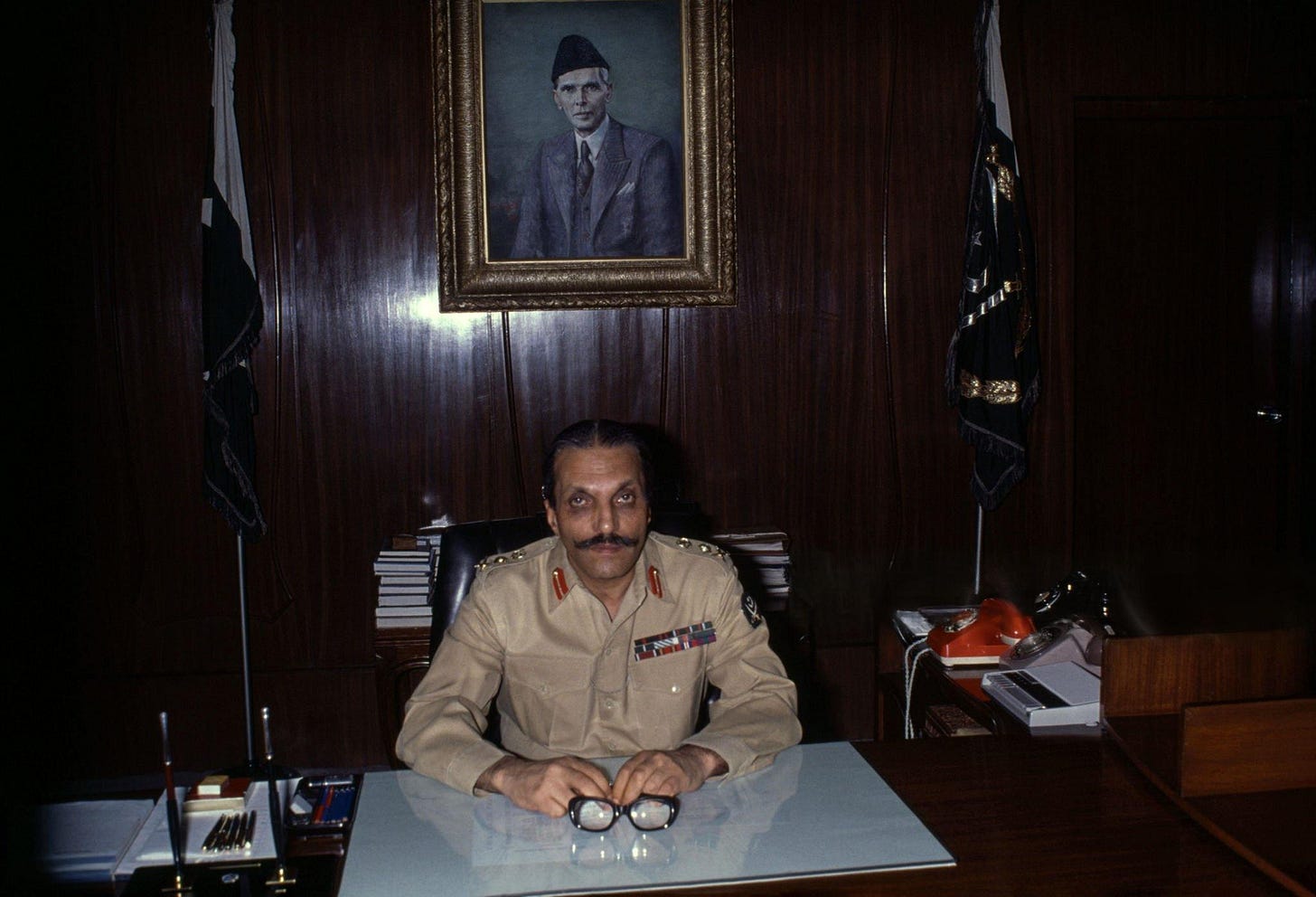 Pakistani military dictator Muhammad Zia ul-Haq in his office, 1977. After seizing power, he spent 11 years overseeing his predecessor's execution, accelerating Pakistan's nuclear program, and transforming the nation into an Islamic state.