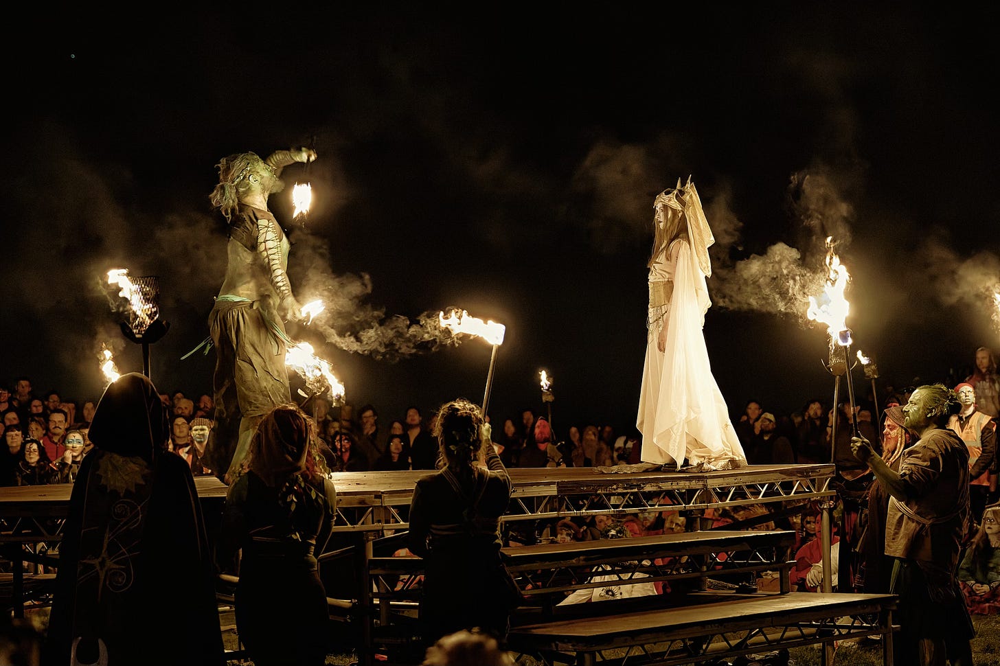 This documentary fieldwork photograph shows the Summer Green Man winning over the May Queen with vigorous fire juggling. Beltane, Edinburgh 2026