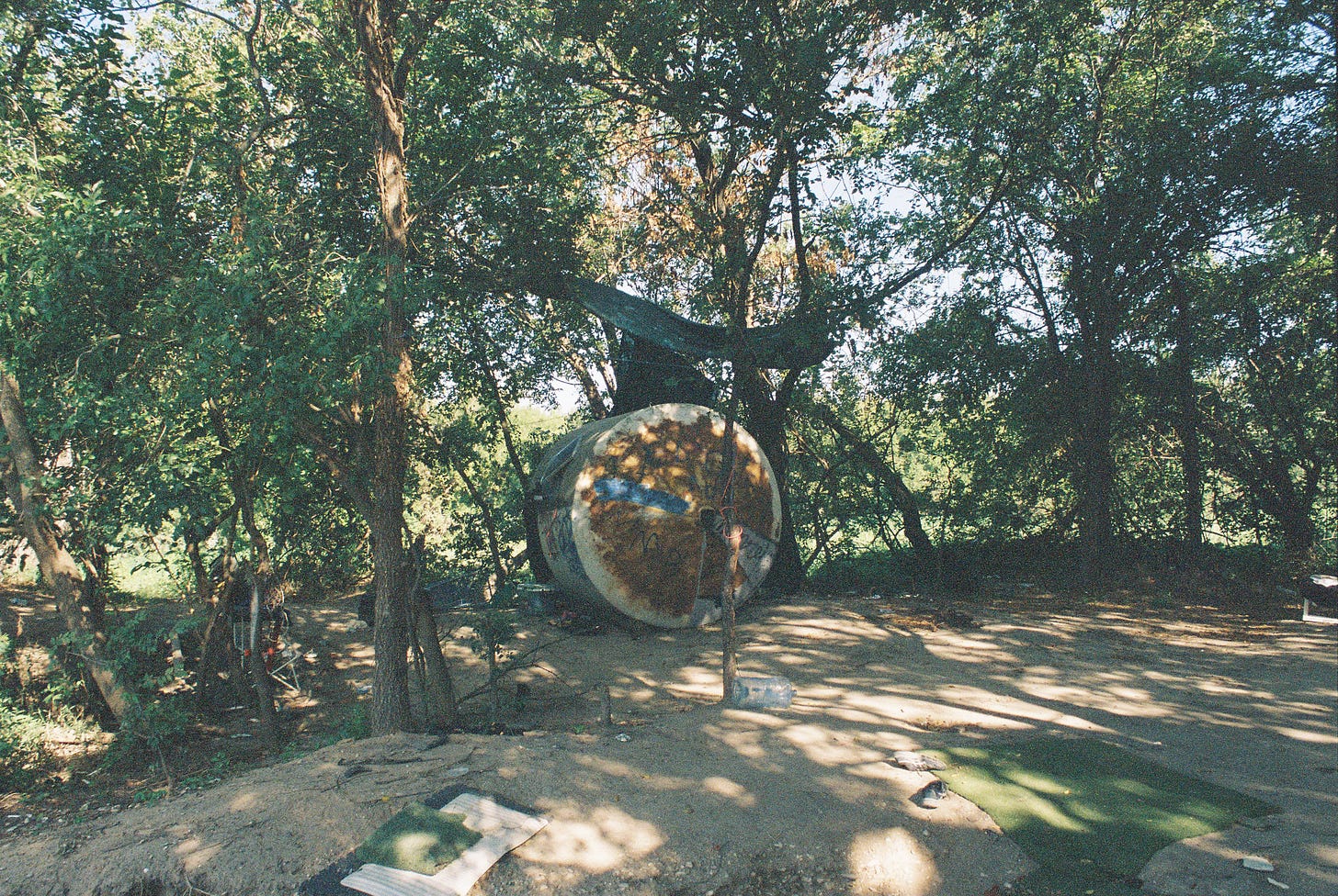 Giant tank repurposed as human shelter in riverside camp