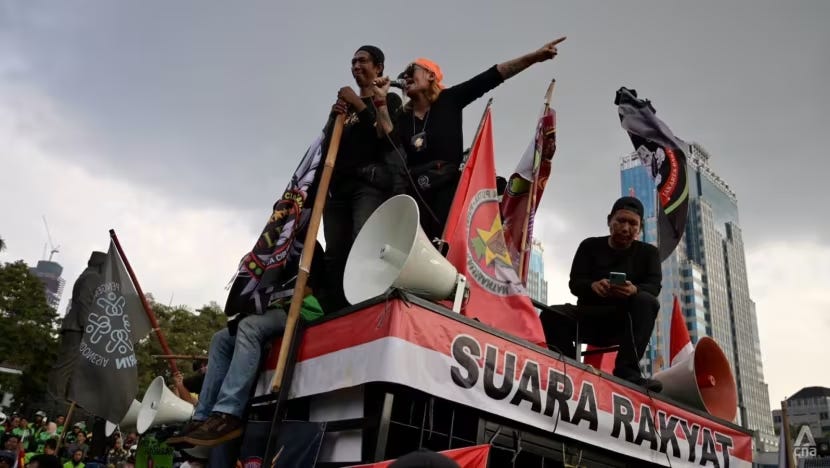 2025年5月20日，抗议者在雅加达市中心的国家纪念碑建筑群旁焚烧轮胎进行示威、站在车顶演讲。来源：CNA