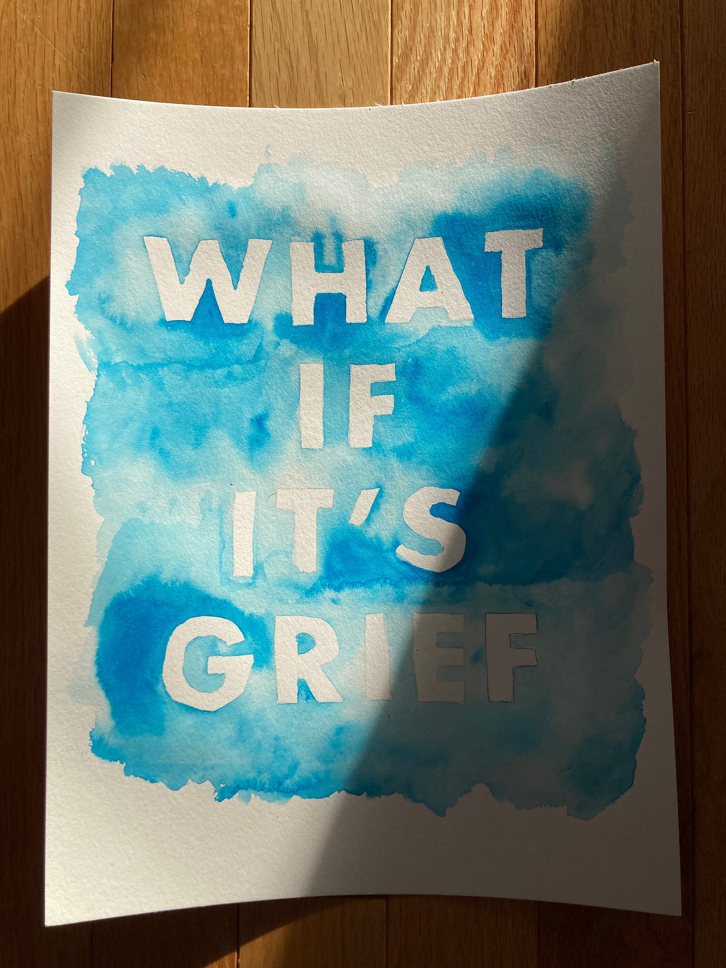 A blue-background wobbly watercolour painting, photographed in afternoon winter sunshine, that asks, "What if it's grief?"
