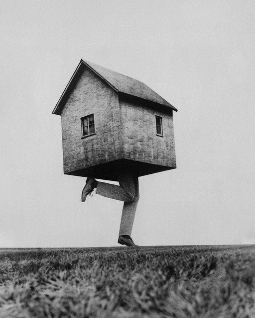 This may contain: a man carrying a house on his back in the middle of an open field with grass