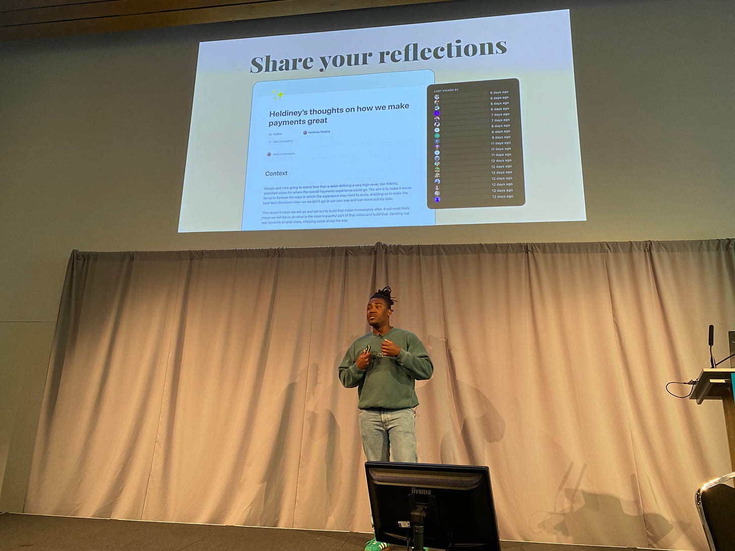 Heldiney Pereira speaking at a conference with a slide showing his blog