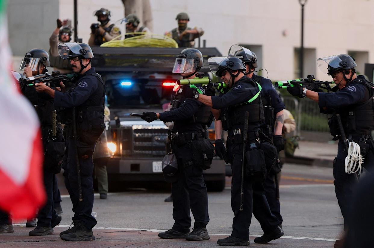 Law enforcement officers shoot non-lethal munitions, as people march as part of the ongoing protests against Immigration and Customs Enforcement (ICE), in Los Angeles, California, U.S. June 11, 2025. REUTERS/Leah Millis