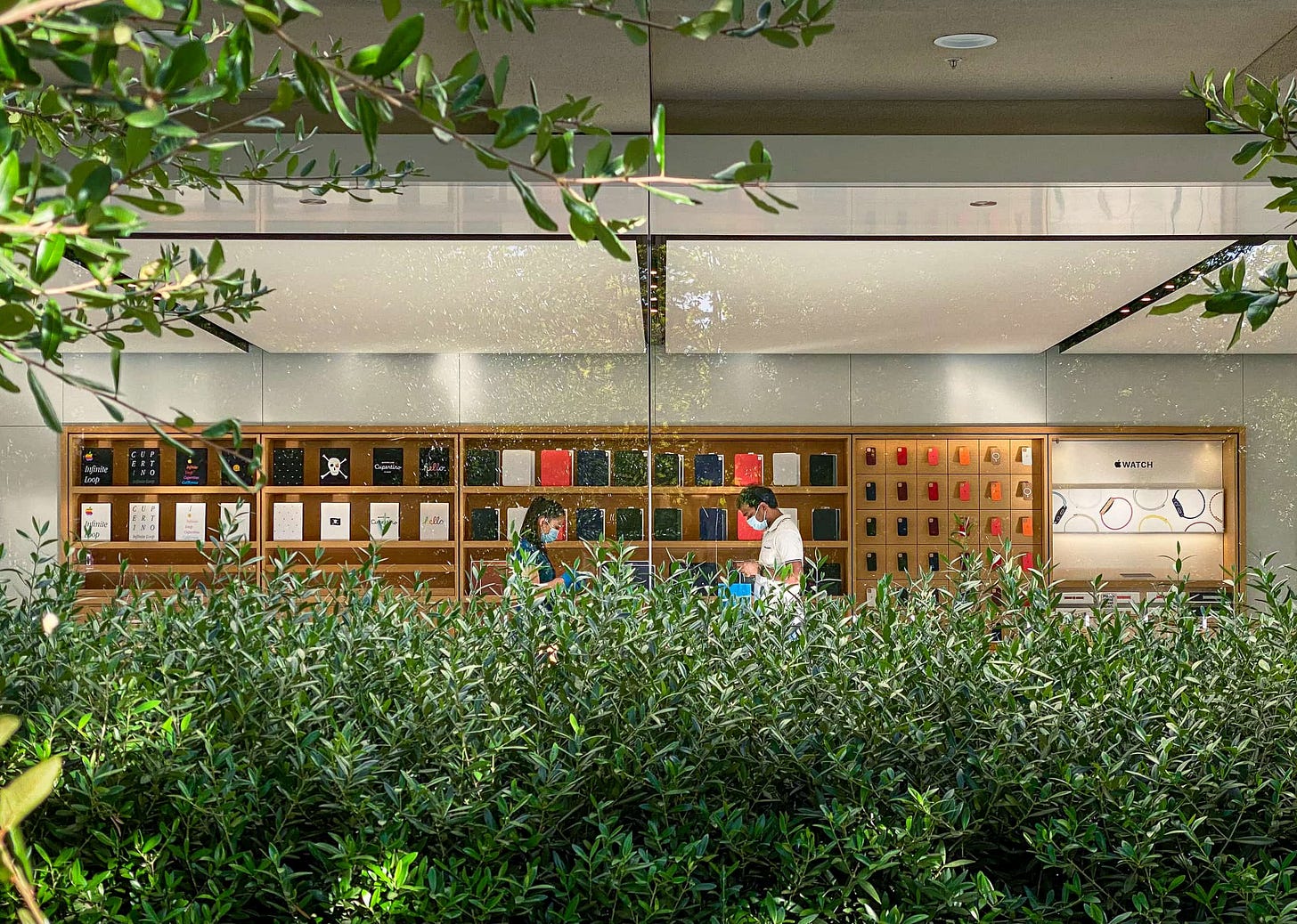 A customer completes a purchase in Apple Infinite Loop. The photo is taken from outside.