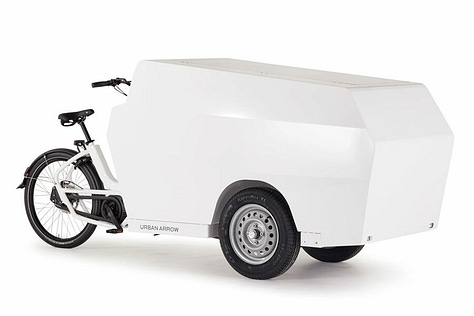 The tender is a tricycle cargobike with two wheels at the front. A gallery of images showing different combinations of Tender cargobikes. One has nothing on, just a platform. Another has a large storage box and another has a large flight case