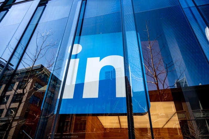 Facade of the LinkedIn office building with its logo visible, reflecting the surrounding cityscape.