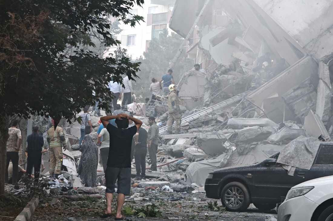 TEHRAN, IRAN - JUNE 13: People look over damage to buildings in Nobonyad Square following Israeli airstrikes on June 13, 2025 in Tehran, Iran. Iran's three top military generals were killed in the attacks that also targeted nuclear and military facilities, according to published reports. Israel described the strikes as preemptive to keep Iran from obtaining nuclear weapons, the reports said. (Photo by Majid Saeedi/Getty Images)