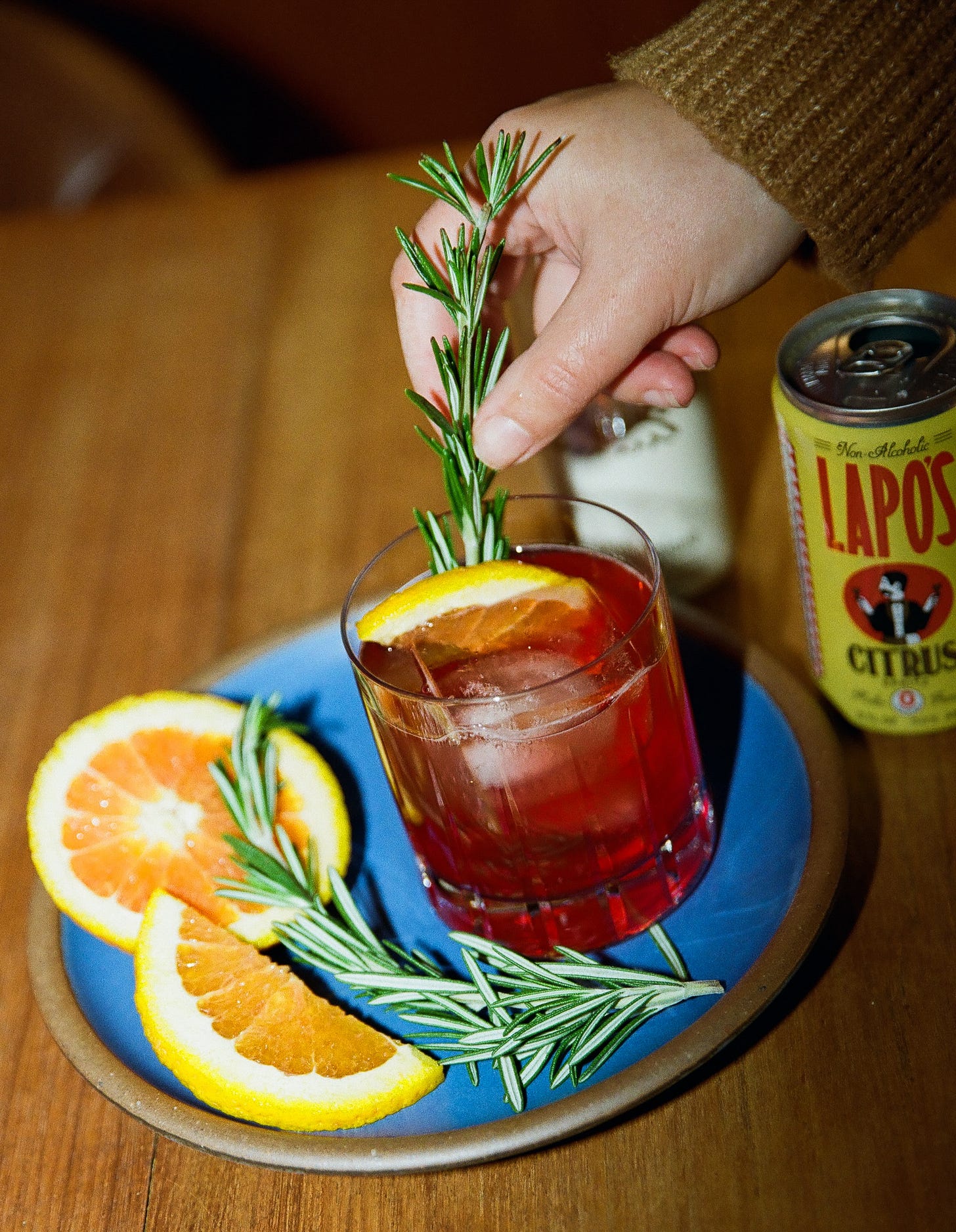 Placing rosemary in drink.