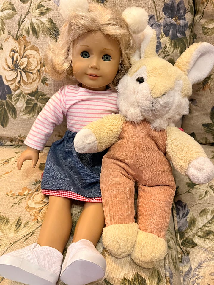 An American girl doll and a plush bunny rabbit.