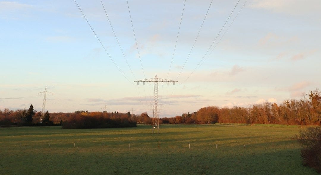 a green field with power lines above it