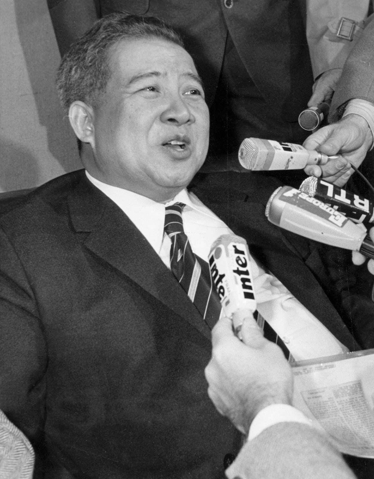 A person in a suit speaking to a person

Description automatically generated