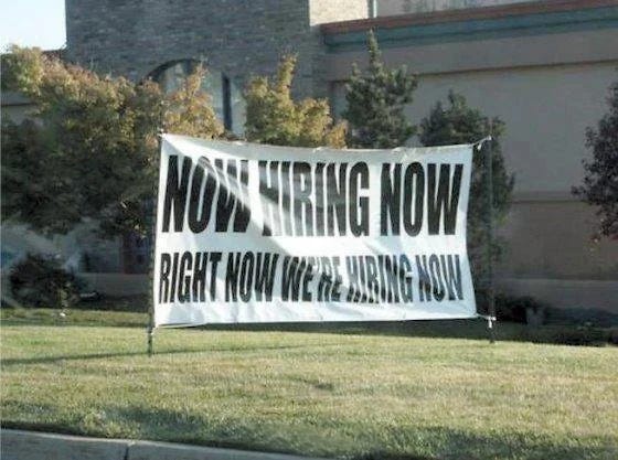 Outdoor banner with the phrase 'Now Hiring Now, Right Now We're Hiring Now' emphasizing urgent recruitment needs Outdoor banner with the phrase 'Now Hiring Now, Right Now We're Hiring Now' emphasizing urgent recruitment needs