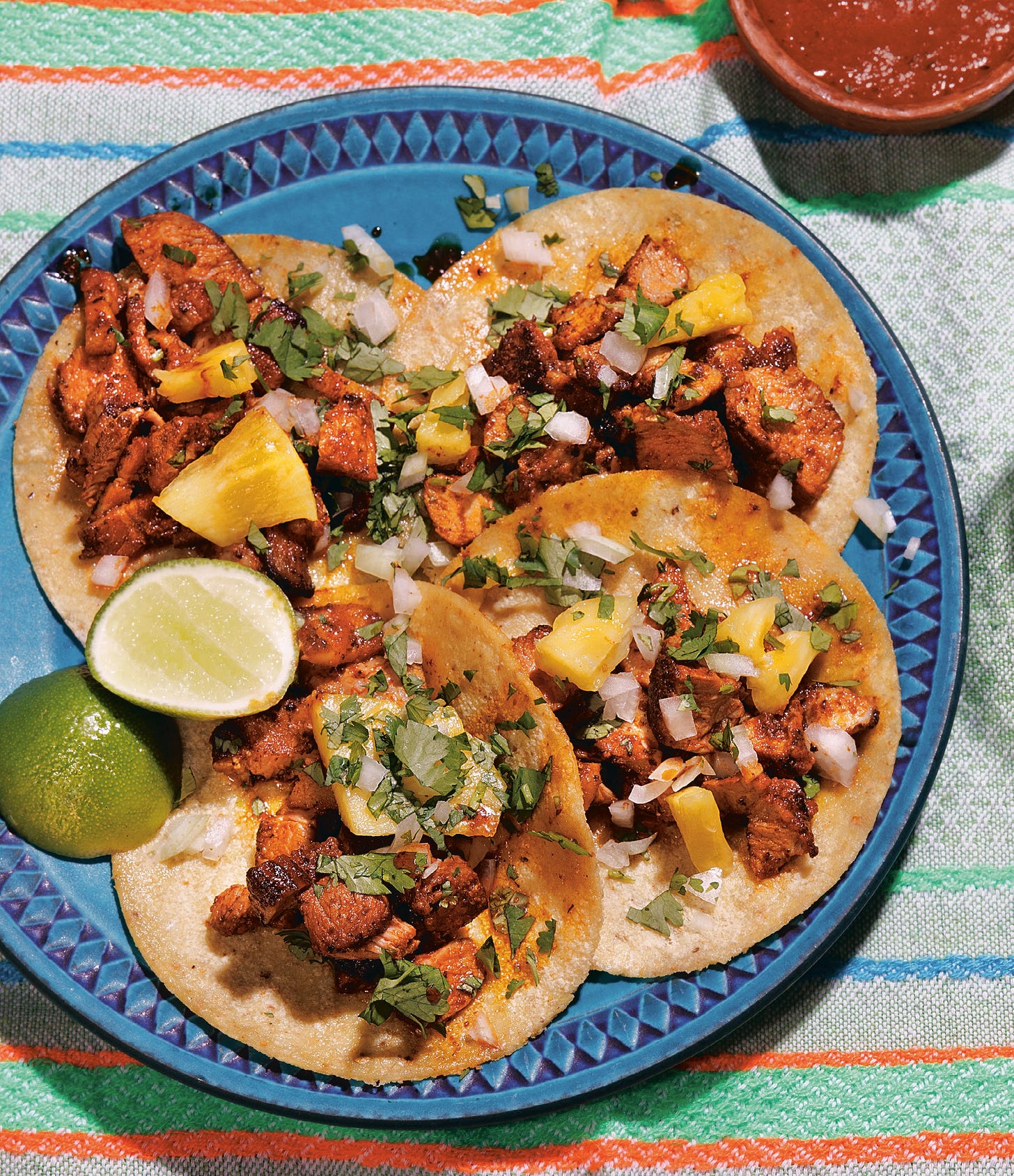 Al Pastor tacos recipe from Vitamina T on a blue plate.