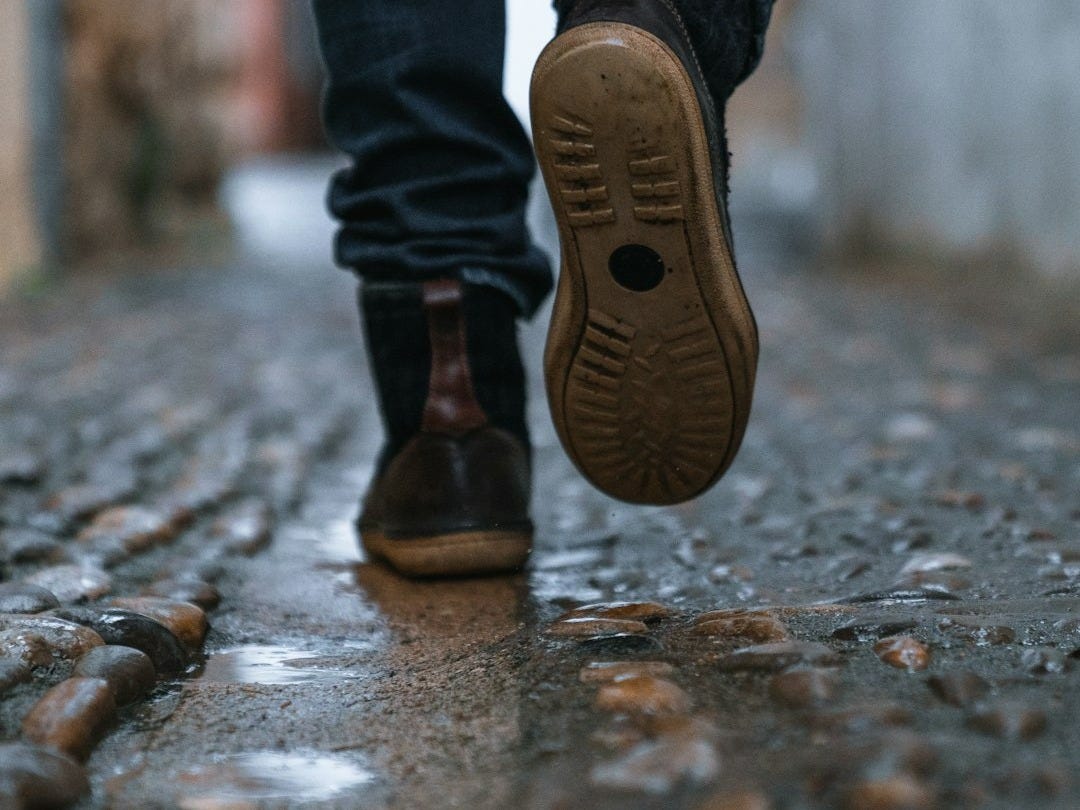 close-up photography of person walking on pavement close-up photography of person walking on pavement