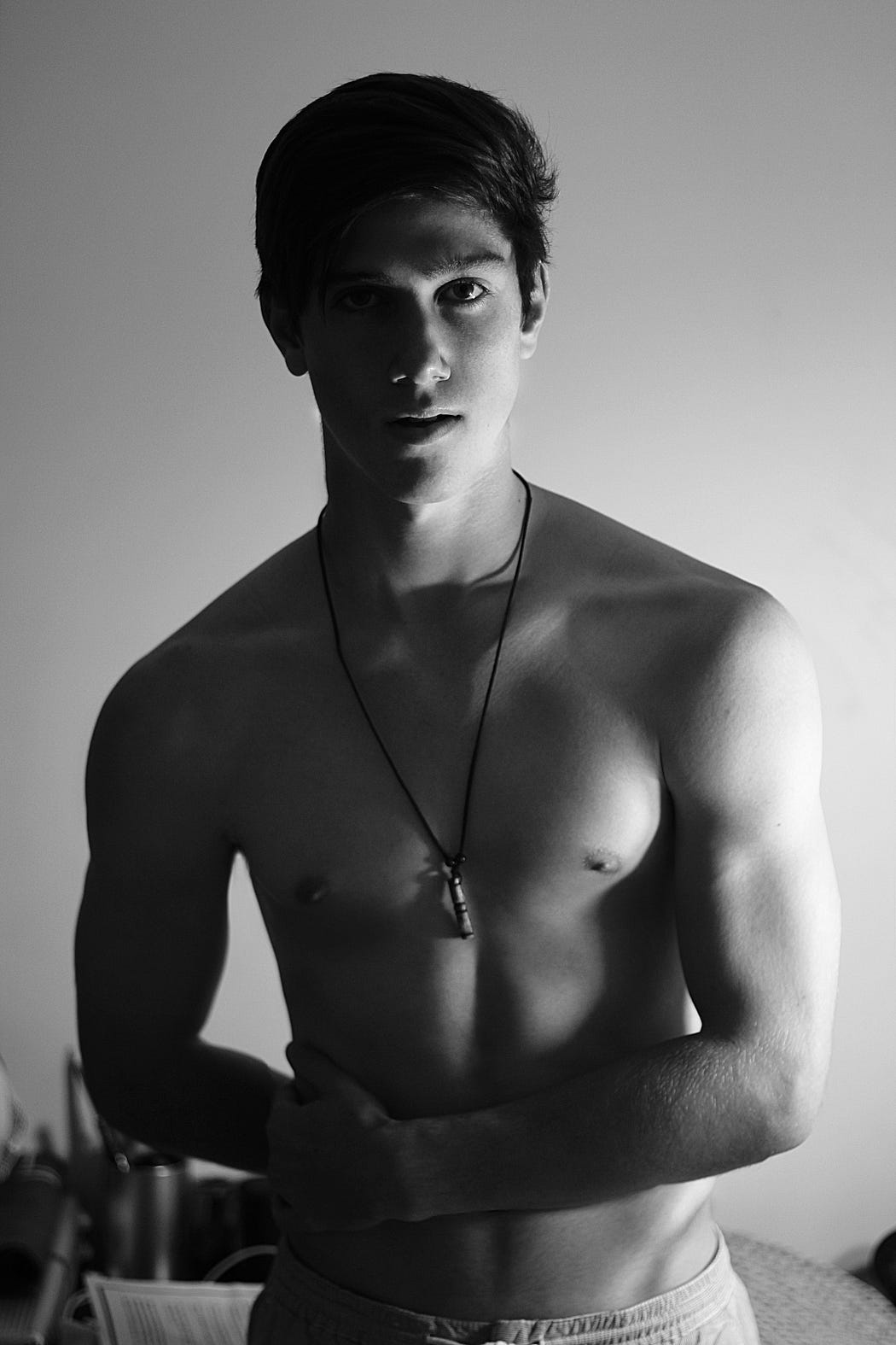 A handsome shirtless young man wearing a necklace A handsome shirtless young man wearing a necklace