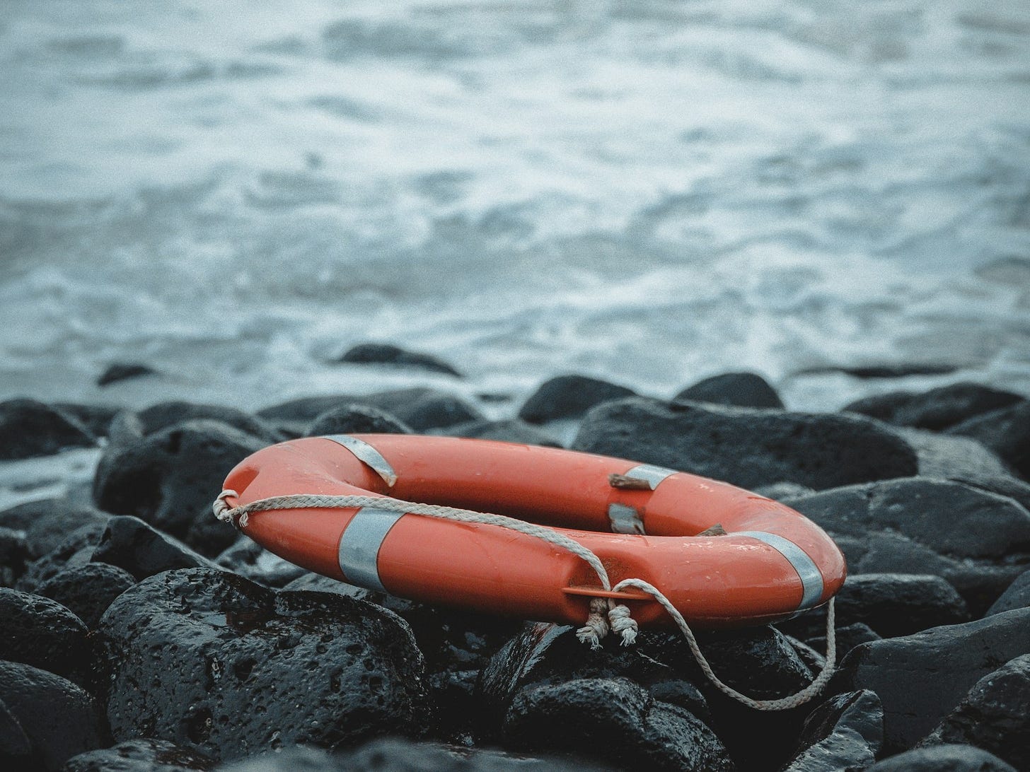 Un salvagente su una spiaggia rocciosa Un salvagente su una spiaggia rocciosa