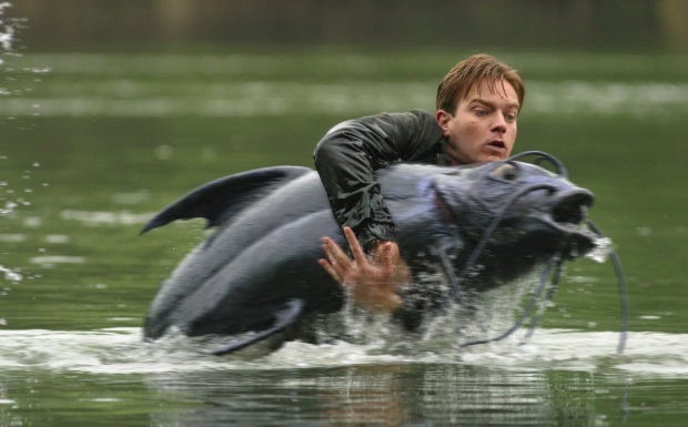 From Big Fish: Ewan McGregor struggles to hold on to a large catfish while standing in a river.