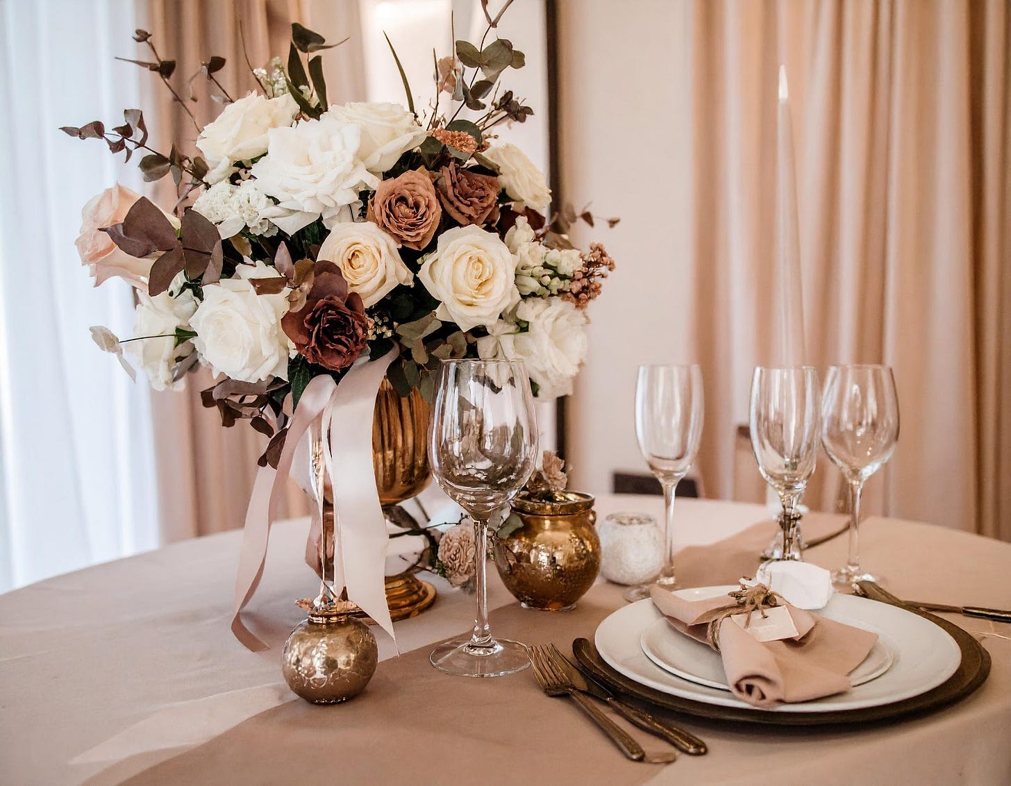 A table with a vase of flowers and glasses

AI-generated content may be incorrect.
