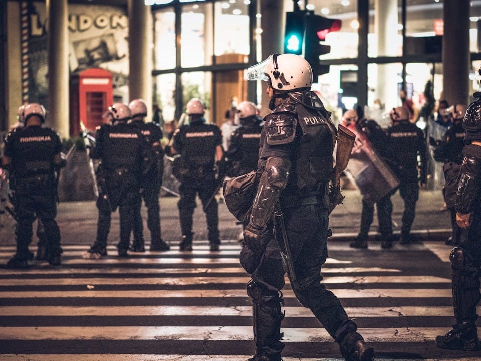 a group of police standing on a street corner