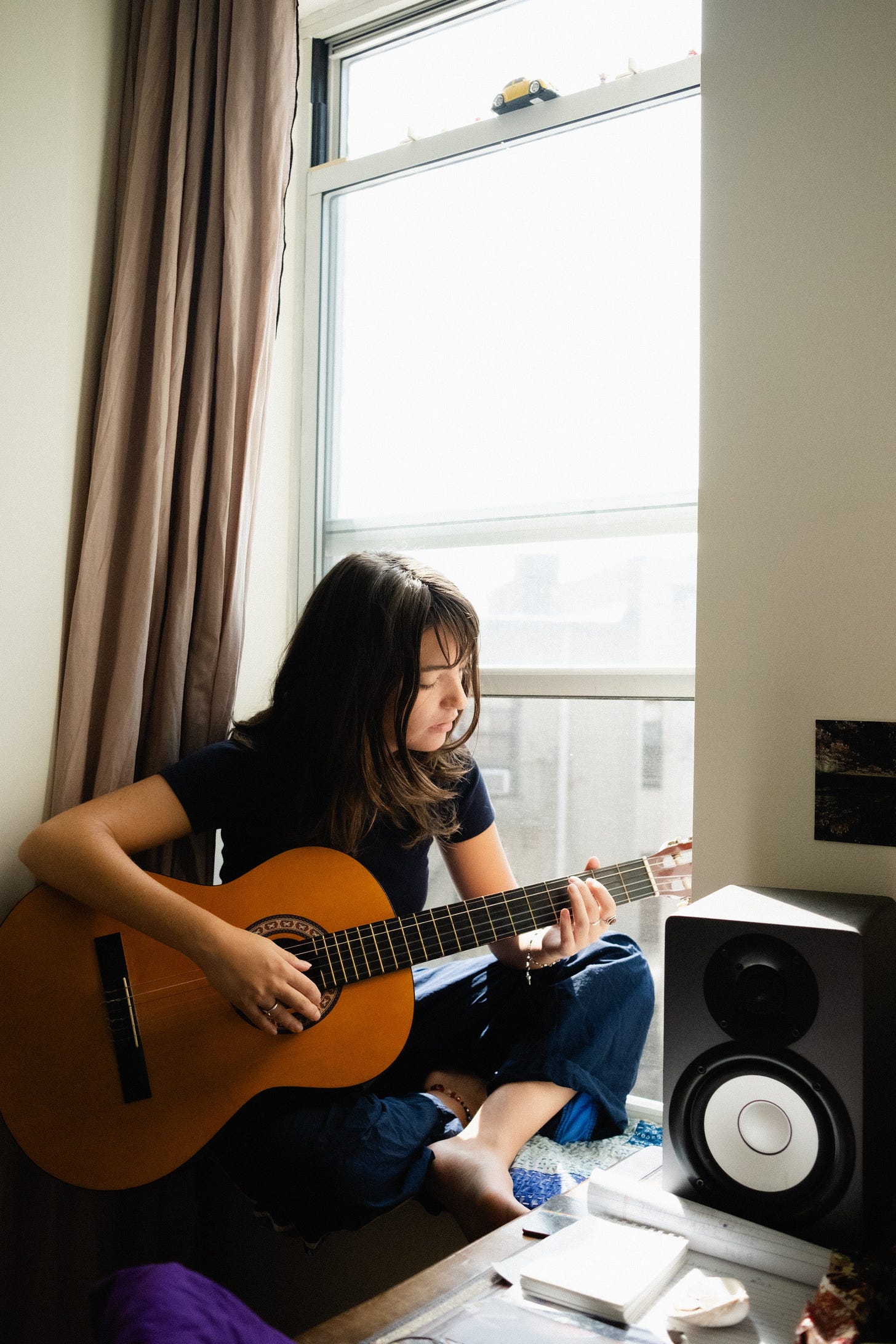 Lily in her window seat with guitar