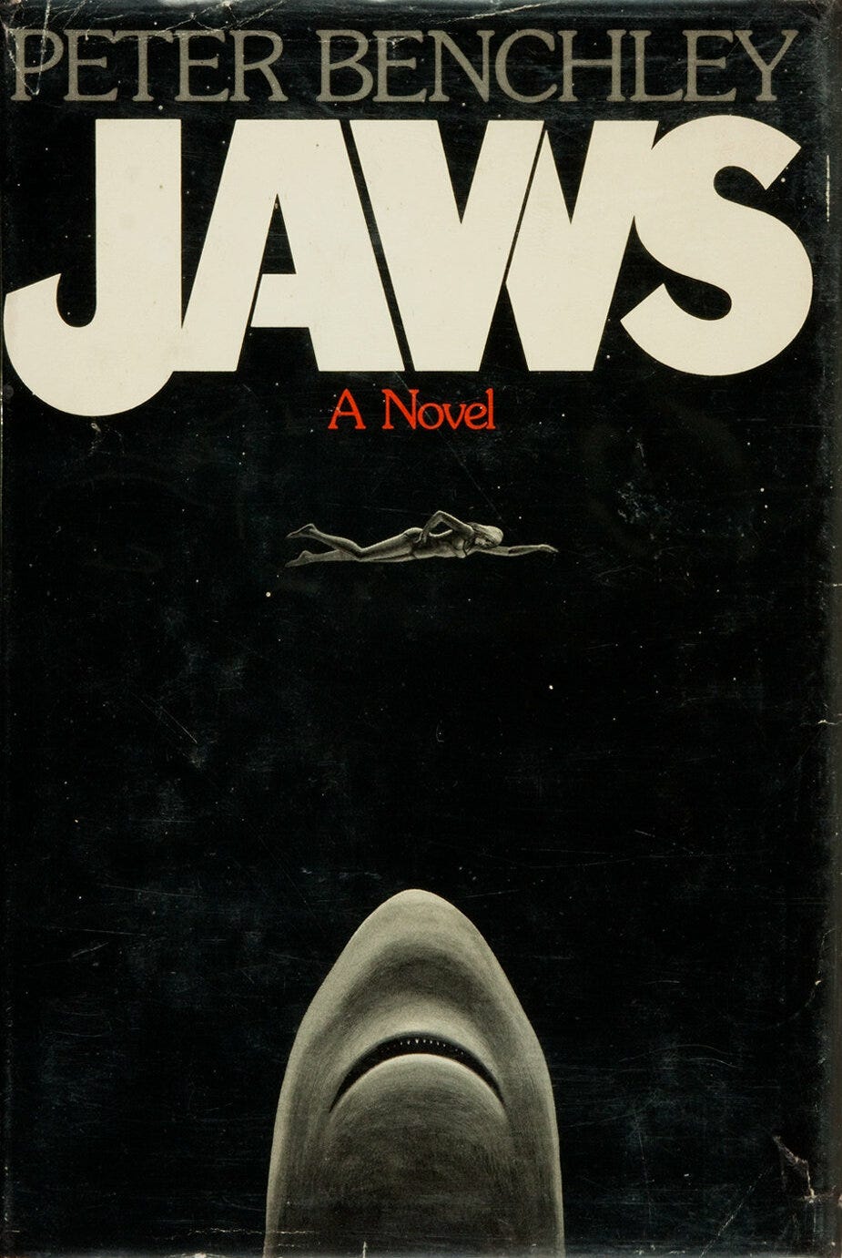 The original cover of Jaws, depicting a shark looming underneath a female swimmer.
