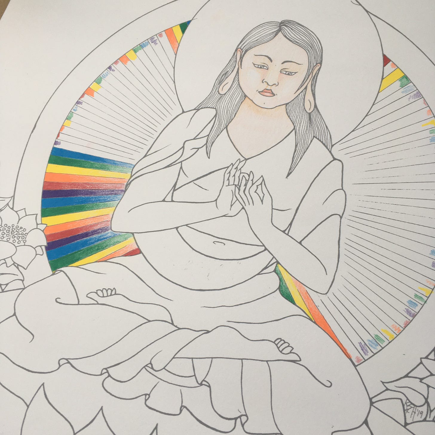 Photo of the progress of colouring in the radiance lines behind a drawing of the Buddha Vairochana. Vairochana is depicted as a soft, round Korean woman with long hair just passed shoulder length, sitting cross-legged with her hands in the bodhyagri mudra.