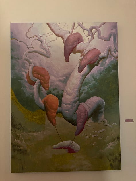 Photo 1: People gathering in a living room with vaulted ceilings. Photo 2: A painting and 3 drawings hung on a wall. Photo 3: A surrealist painting of amorphous creatures hanging from a tree. Photo 4: People gathered around the surrealist painting. Photo 5: A collage with cartoon images of a trail to the ocean and a butterfly, and bold text reading: traces of a path, losing sight of the sea. Photo 6: People and a red dog gathered around a man playing guitar. Photo 7: Ink and pastel drawings of two circles meeting. Photo 8: a pile of shoes at a door. Photo 9: Silhouettes of people through tall windows from outside at night.