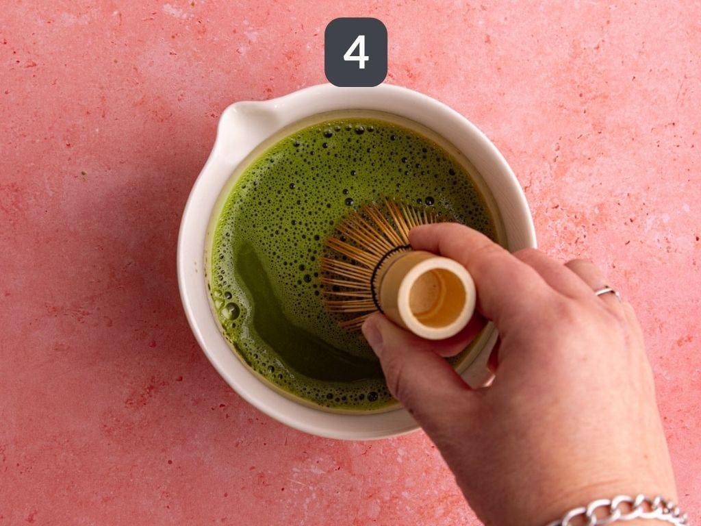 Raspberry matcha latte step 4 - add cold water and whisk.