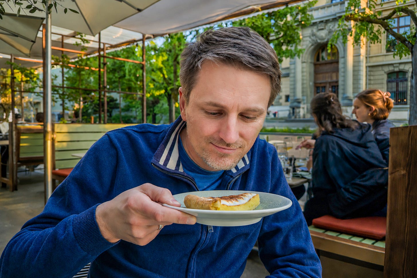 Der Biologe Martin Reich sitzt auf der Terrasse des Restaurants «Löscher» in Bern und hält einen Teller mit Apfeltarte und Meringue dicht unter die Nase. Er prüft den Duft des Desserts konzentriert, während im Hintergrund Bäume, Sonnenschirme und weitere Gäste zu sehen sind. Der Biologe Martin Reich sitzt auf der Terrasse des Restaurants «Löscher» in Bern und hält einen Teller mit Apfeltarte und Meringue dicht unter die Nase. Er prüft den Duft des Desserts konzentriert, während im Hintergrund Bäume, Sonnenschirme und weitere Gäste zu sehen sind.