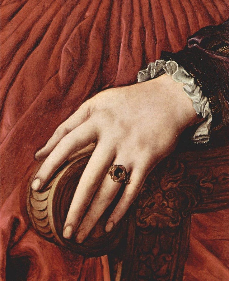 This may contain: a close up of a person's hand with a ring on it