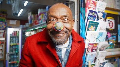 Close-up image of Sir Lenny Henry wearing a red nose for Comic Relief. 