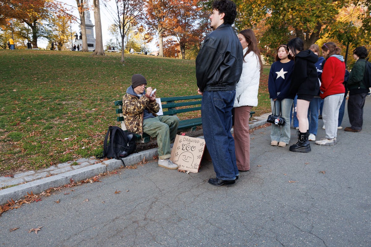 street artist sketching as a group of people wait in line beside a park bench in fall