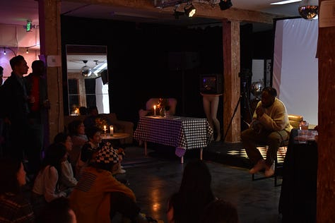pictures of author signing book at book launch event, and aesthic placement of candles, dim light, and books displayed in accordion style