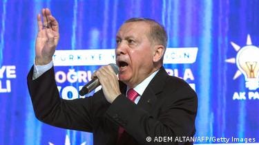 Recep Tayyip Erdogan speaks into a microphone Recep Tayyip Erdogan speaks into a microphone