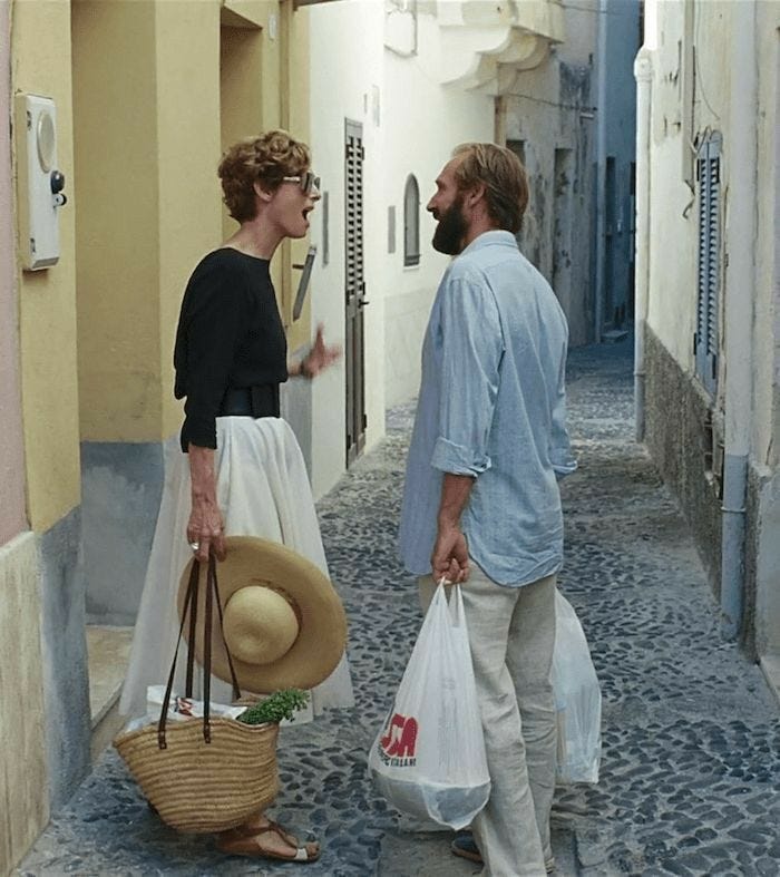 This may contain: a man and woman are walking down an alley way carrying bags with hats on them