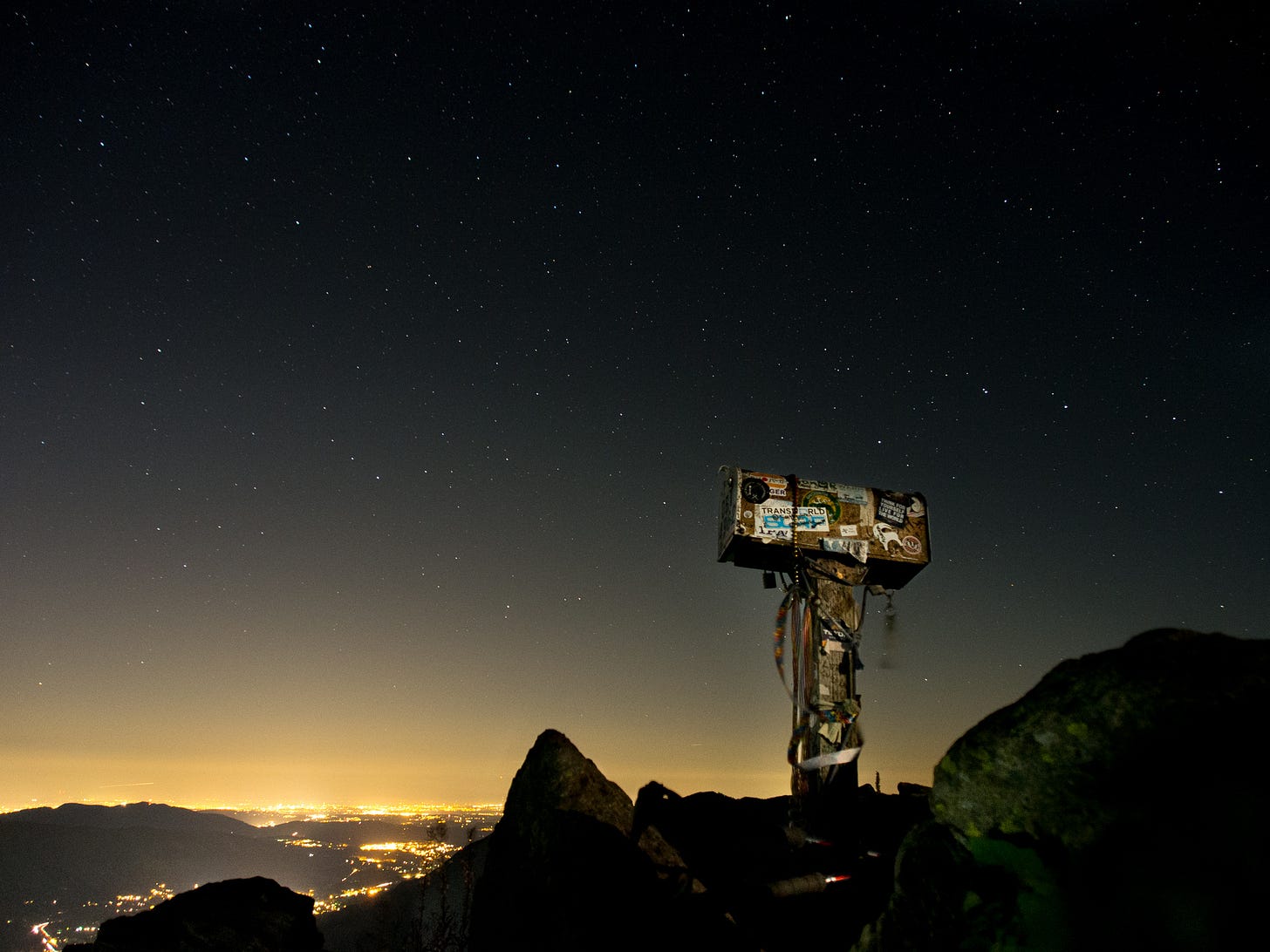 Image of a mailbox atop a mountain peak against a background of night stars. Image of a mailbox atop a mountain peak against a background of night stars.