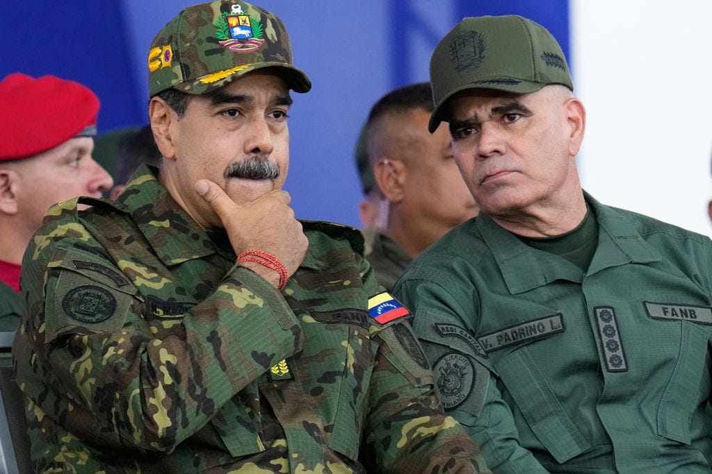 Venezuelan President Nicolas Maduro, left, listens to Defence Minister Vladimir Padrino Lopez during a government-organised civic-military march in Caracas, Venezuela.