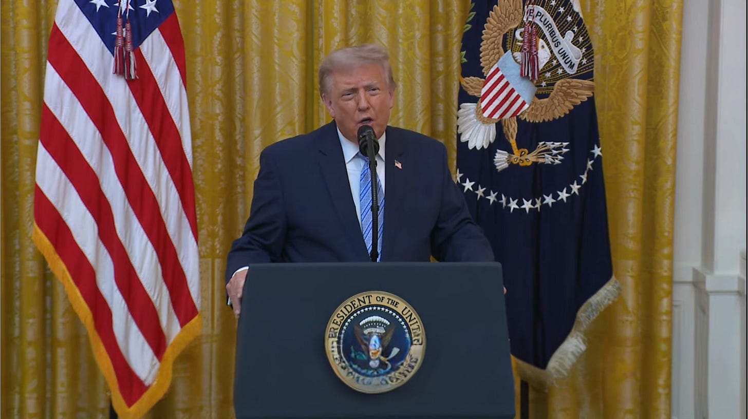 The president speaks behind a lectern in the White House East Room, with the U.S. flag and presidential flag behind him. The president speaks behind a lectern in the White House East Room, with the U.S. flag and presidential flag behind him.