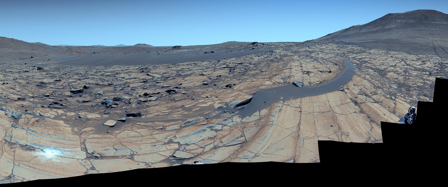 A blue sky over a rocky desert on the planet Mars.