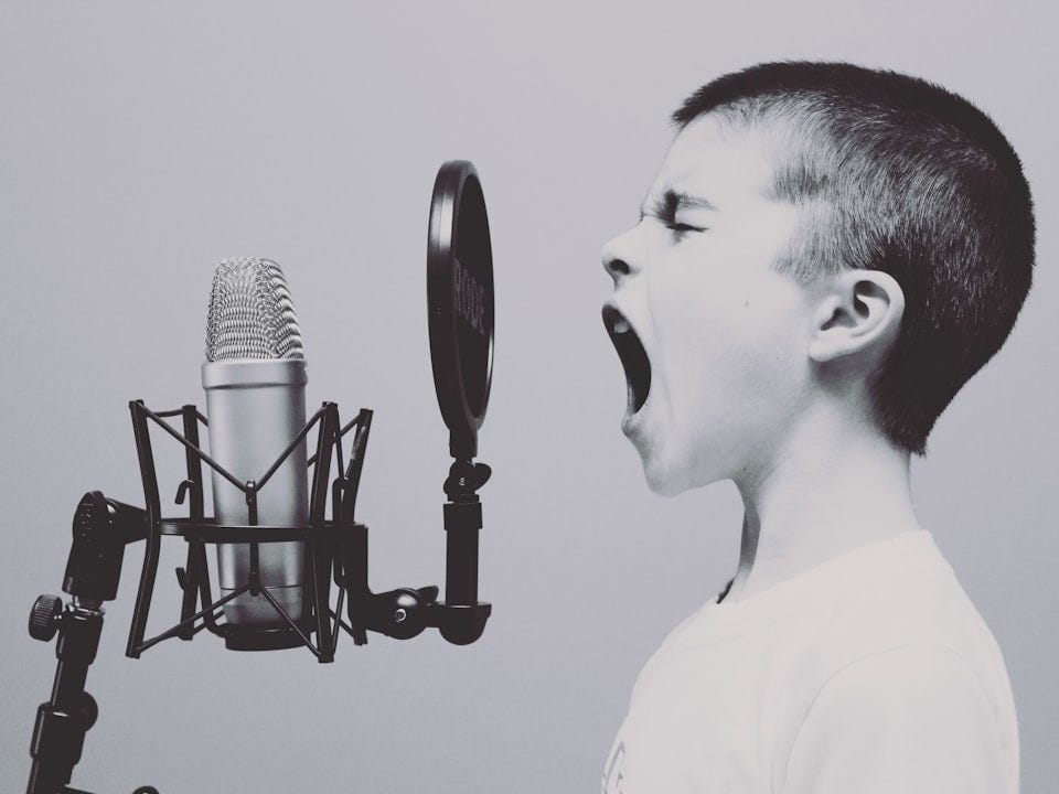 boy singing on microphone with pop filter boy singing on microphone with pop filter