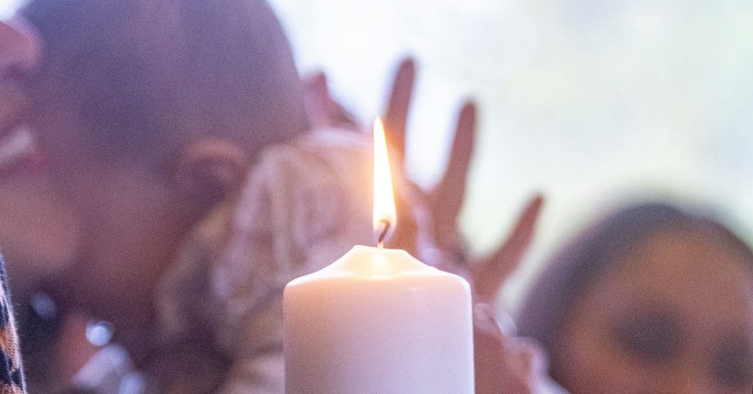 A woman holding a lit candle in her hands