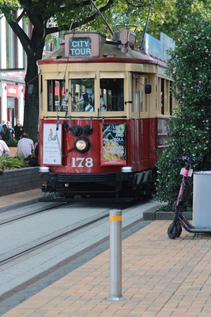 red and white tram on road during daytime, group travel red and white tram on road during daytime, group travel